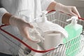 Woman with shopping basket full of antiseptics and toilet paper. Panic caused by virus Royalty Free Stock Photo