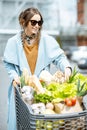 Woman with shopping cart full of food outdooors Royalty Free Stock Photo