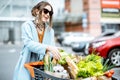 Woman with shopping cart full of food outdooors Royalty Free Stock Photo