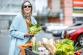 Woman with shopping cart full of food outdooors Royalty Free Stock Photo