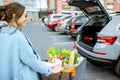 Woman with shopping cart on the outdoor parking