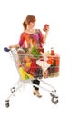 Woman with Shopping cart reading label Royalty Free Stock Photo
