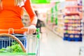 Woman with shopping cart in supermarket Royalty Free Stock Photo