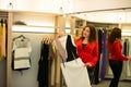 Woman shopping choosing dresses looking in mirror uncertain Royalty Free Stock Photo