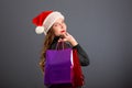 Woman shopping for christmas gifts. Young caucasian girl looking up smiling with shopping bags and santa hat. Copy space on the Royalty Free Stock Photo