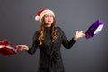 Woman shopping for christmas gifts. Young caucasian girl looking up smiling with shopping bags and santa hat. Copy space on the Royalty Free Stock Photo