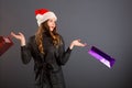 Woman shopping for christmas gifts. Young caucasian girl looking up smiling with shopping bags and santa hat. Copy space on the Royalty Free Stock Photo