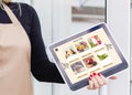 Woman shopping food online using a digital tablet at the kitchen, close-up view on a tablet screen. Concept of buying Royalty Free Stock Photo