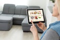 Woman shopping food online using a digital tablet at the kitchen, close-up view on a tablet screen. Concept of buying Royalty Free Stock Photo