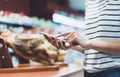 Woman shopping healthy food in supermarket background. Close up view girl buy products using digital gadget in store. Hipster Royalty Free Stock Photo