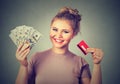 Woman shopping holding showing credit card and cash dollar banknotes bills Royalty Free Stock Photo