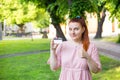 Young caucasian woman stay in park and show white credit card with black magnet line. Shopping and retail concept Royalty Free Stock Photo