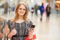 Woman In Shopping Mall Using Mobile Phone Royalty Free Stock Photo