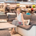 Woman shopping for new sofa in furniture store.