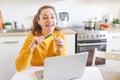 Woman shopping online and paying with gold credit card. Young girl sitting with laptop buying on Internet enter credit card Royalty Free Stock Photo