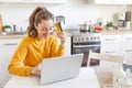 Woman shopping online and paying with gold credit card. Young girl sitting with laptop buying on Internet enter credit Royalty Free Stock Photo