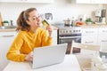 Woman shopping online and paying with gold credit card. Young girl sitting with laptop buying on Internet enter credit card Royalty Free Stock Photo