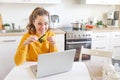 Woman shopping online and paying with gold credit card. Young girl sitting with laptop buying on Internet enter credit card Royalty Free Stock Photo