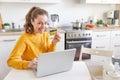 Woman shopping online and paying with gold credit card. Young girl sitting with laptop buying on Internet enter credit card Royalty Free Stock Photo