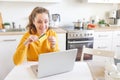 Woman shopping online and paying with gold credit card. Young girl sitting with laptop buying on Internet enter credit card Royalty Free Stock Photo