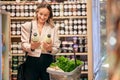 Woman, shopping and organic milk for diet, health or nutrition in store, supermarket or grocery shop. Happy, vegan girl Royalty Free Stock Photo