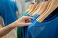 Woman shopping shirt in clothing store. Woman choosing clothes. Shirt on hanger hanging on rack in clothing store. Fashion retail Royalty Free Stock Photo