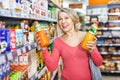 Woman shopping for sweet drinks at supermarket