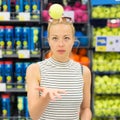 Woman shopping tennis balls in sportswear store. Royalty Free Stock Photo