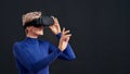 Woman with short hair in blue turtleneck wearing virtual reality headset, vr glasses isolated over dark background Royalty Free Stock Photo
