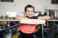 Woman with short hair in pink wear resting in gym after workout with barbell. Royalty Free Stock Photo