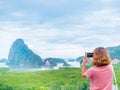 Woman with short hair using smart phone take a photo seascape view