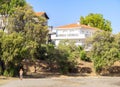 A woman in shorts and a baseball cap runs on the beach with villas in the city of Halkida on the Greek island of Evia, Greece