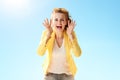 Woman shouting through megaphone shaped hands against blue sky Royalty Free Stock Photo