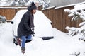 woman with shovel cleaning snow aeound car. Winter shoveling. Removing snow after blizzard