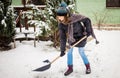 woman with shovel cleaning snow. Winter shoveling. Removing snow after blizzard