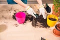 Woman with shovel, soil, flowerpots and plant on table