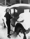 Woman shoveling snow off car Royalty Free Stock Photo