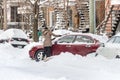 A woman is shoveling snow to free her stuck car Royalty Free Stock Photo