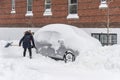 A woman is shoveling snow to free her stuck car Royalty Free Stock Photo