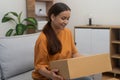 woman showcases her online order delivery, exemplifying the comfort of receiving goods at home.