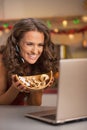 Woman showing christmas cookies while having video chat on laptop Royalty Free Stock Photo