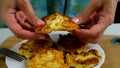 Woman showing cooked fried potatoes pancakes, draniki on plate on kitchen.