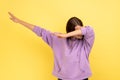 Woman showing dab dance pose, famous internet meme, performing dabbing trends.