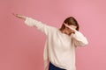 Woman showing dab dance pose, internet meme of triumph, performing dabbing trends with hand gesture. Royalty Free Stock Photo