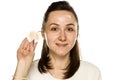 A woman showing dirty cotton pad on white