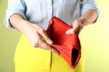 Woman showing empty wallet on light green, closeup Royalty Free Stock Photo