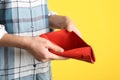 Woman showing empty wallet on yellow background Royalty Free Stock Photo