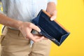 Woman showing empty wallet on yellow, closeup Royalty Free Stock Photo