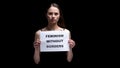 Woman showing feminism without borders sign, rights of women, dark background