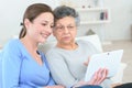 Woman showing grandmother how to use digital tablet Royalty Free Stock Photo